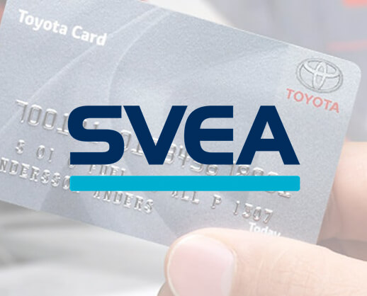 Hand håller i en Toyota-kort och svea ekonomi logotyp