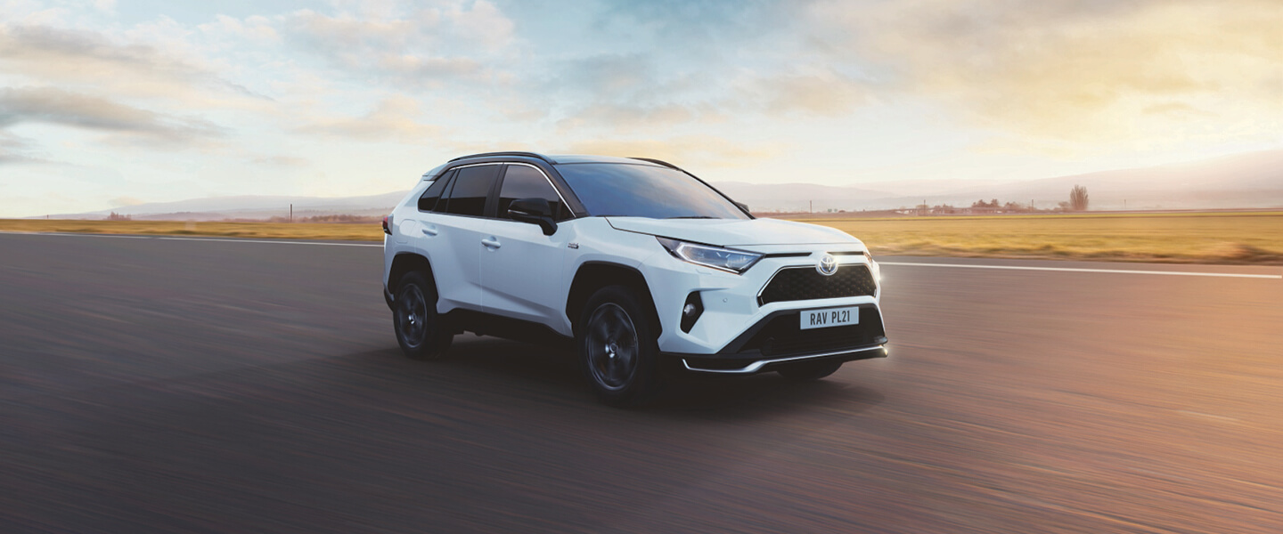 Vit RAV4 Laddhybrid i skymning