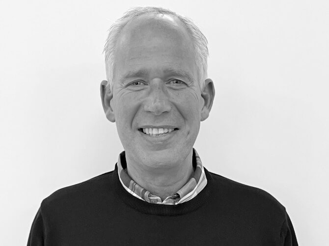 En säljare från Lindströms Bil ler och tittar in i kameran.