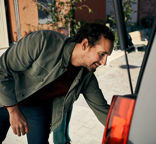 Man som kollar lastutrymme i en Toyota