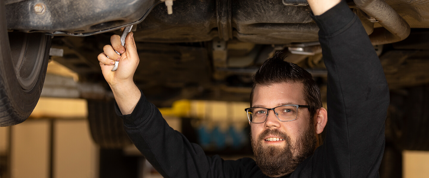 Lindströms Bils servicetekniker utför service under en bil.