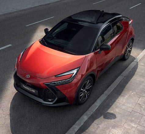 En kopparfärgad Toyota C-HR står parkerad.