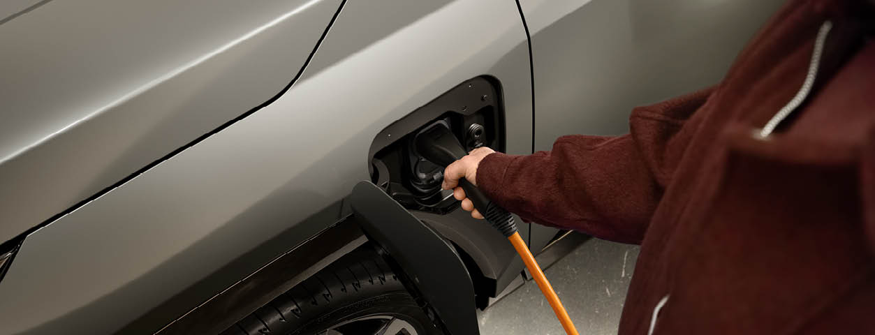 En person laddar en elbil.